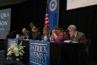 The panel prays at 2024 Faith & Reason